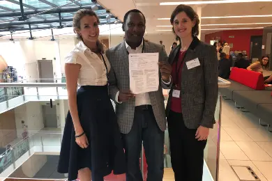 The three founders of Prowibo posing for a photo together. Majeks Walker holds the charity's official registration documents up for the camera.