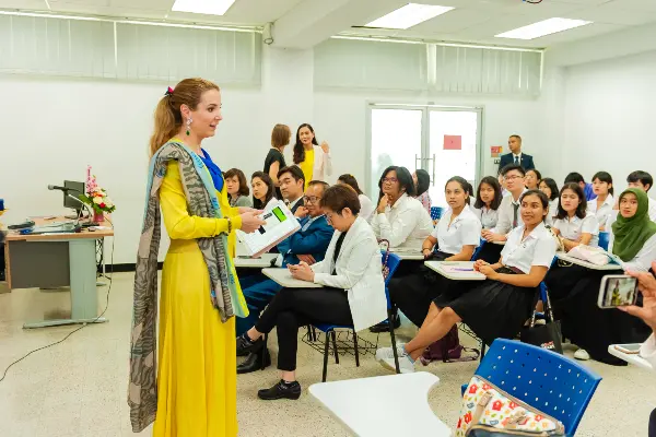 Prowibo Professor Tessy de Nassau stands in front of a class of Thai students. The class is watching intently as she teaches.
